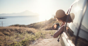 Young woman with her arm out of a vehicle on a road trip in Ohio.