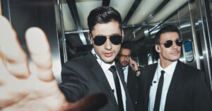 Two men in suits and sunglasses.