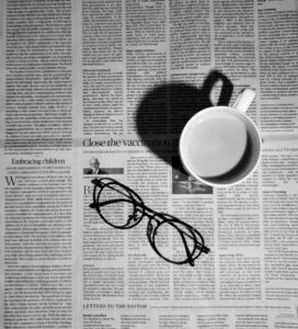 glasses and a mug on a newspaper