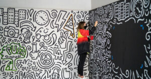 a woman painting a mural