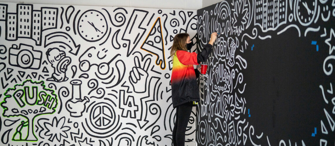 a woman painting a mural
